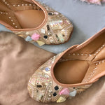 Handcrafted beautiful lustrous gold juttis embroidered with mirrors, sequins, pearls, tassels and katdana for women.