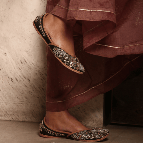 Ethnic Handcrafted black juttis embroidered with different types of stones, crystals, silver pipes, zari and beadwork for women.