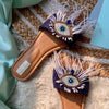 Handcrafted dynamic evil-eye blue sliders embellished with crystals and feathers for women.